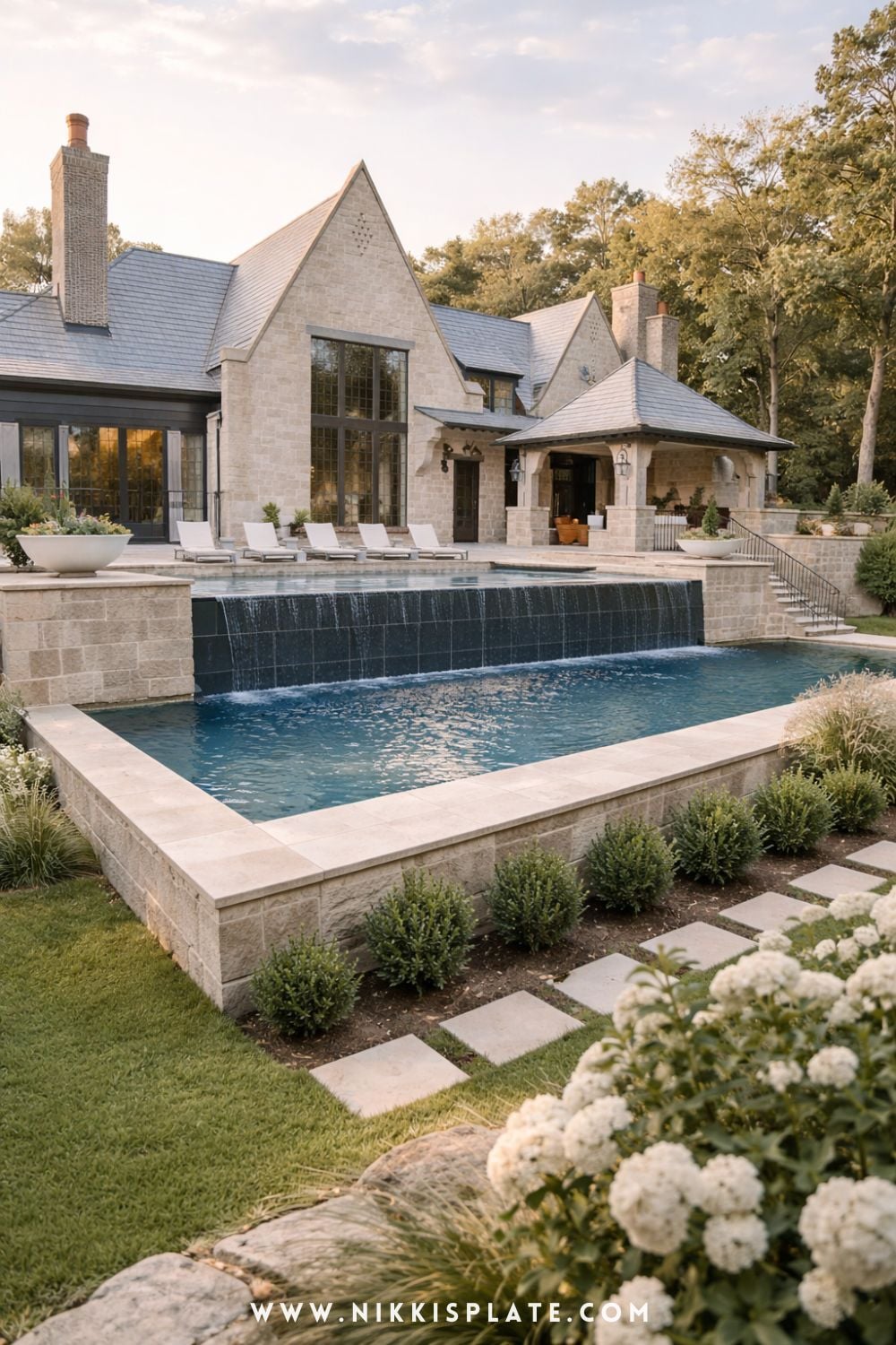 Tiered hillside pool with retaining walls and infinity edge design in a landscaped sloped backyard