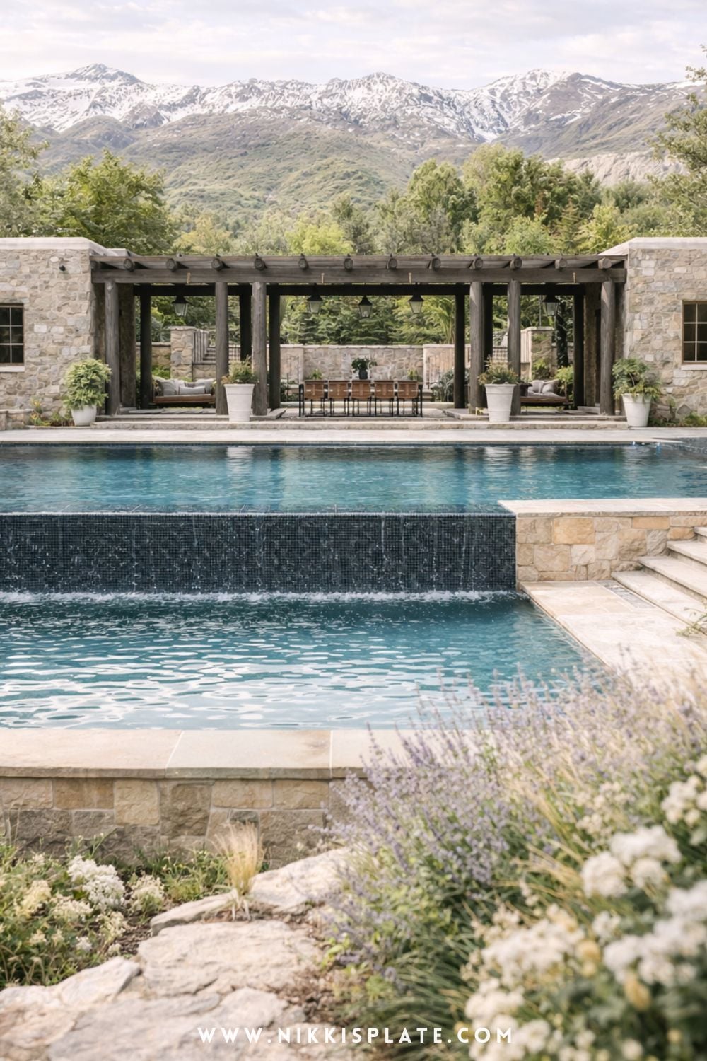 Tiered hillside pool with retaining walls overlooking mountains with stone landscaping and layered backyard design