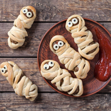 Easy Halloween Hot Dog Mummy Recipe; two ingredient mummy dogs using crescent dough and hot dogs. Easy fun Halloween recipe for kids!