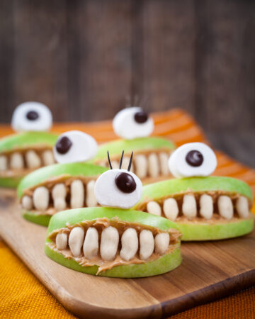 Halloween Apple and Peanut Butter Monster Mouths Recipe; simple healthy Halloween snack for kids using apples, peanut butter, peanuts, marshmallows and chocolate chips.
