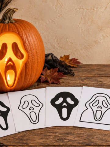 Glowing Scream-inspired carved pumpkin beside five printable pumpkin stencil pages on a farmhouse table.