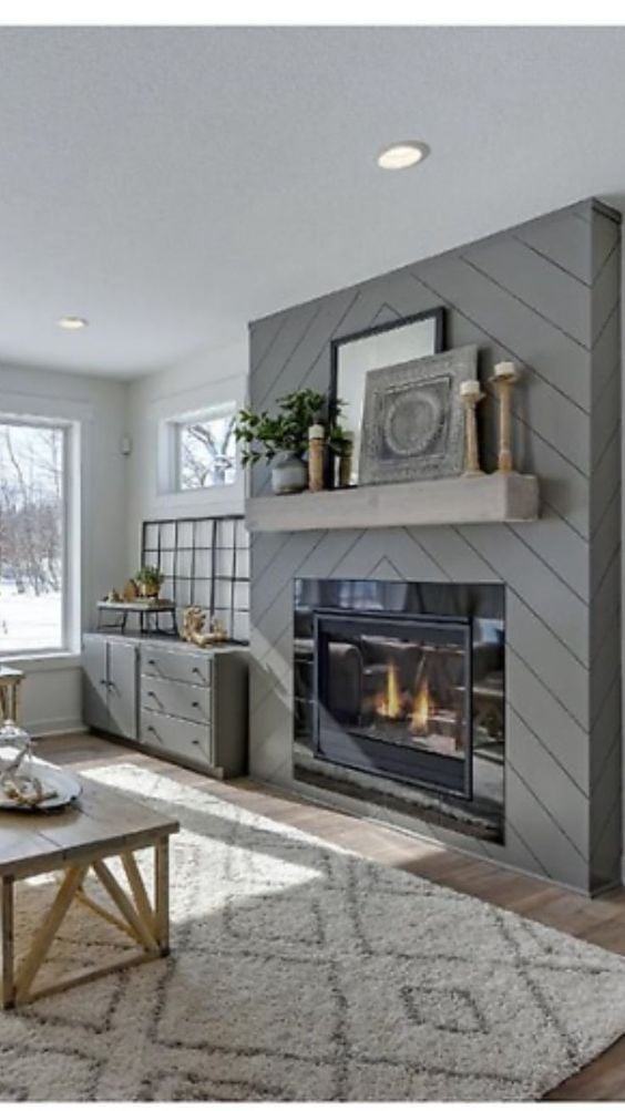 Chevron shiplap fireplace in soft gray with rustic mantel in this farmhouse living room