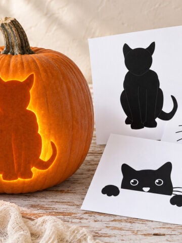 Glowing cat jack-o-lantern beside printable cat pumpkin carving patterns on a bright farmhouse table.
