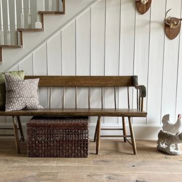 natural wood flooring in cozy farmhouse entryway with bench and shiplap wall