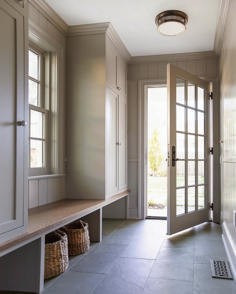 slate tile flooring in farmhouse mudroom with built in bench and storage