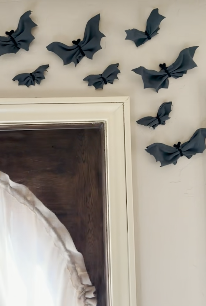 Handmade no-sew fabric bats created with pipe cleaners and dark fabric scraps, attached above a doorway.