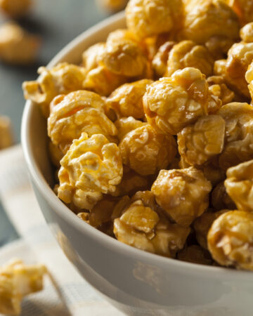 Homemade Golden Caramel Popcorn in a Bowl - Chewy Caramel Coated Popcorn Recipe; a chewy gooey version of caramel popcorn! Packed into pretty decorative bags, makes a great gift for family and coworkers!