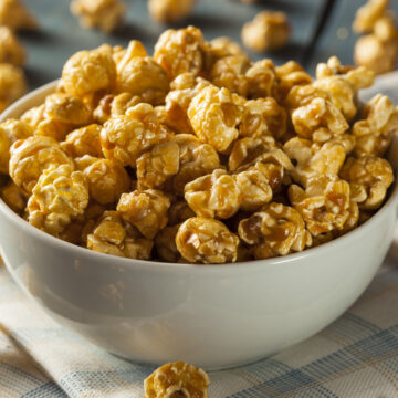 Homemade Golden Caramel Popcorn in a Bowl - Chewy Caramel Coated Popcorn Recipe; a chewy gooey version of caramel popcorn! Packed into pretty decorative bags, makes a great gift for family and coworkers!