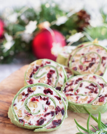 These Cranberry Walnut Pinwheels are the perfect make ahead Christmas appetizer or snack. Sweet feeling with dried cranberries, with the crunch of walnuts all mixed in a creamy filling!