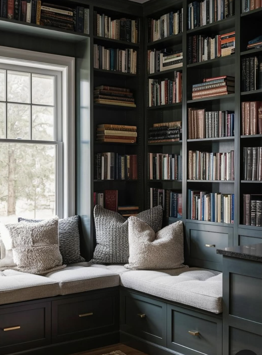 Built-in dark wood bookshelves with cozy window seat and layered pillows