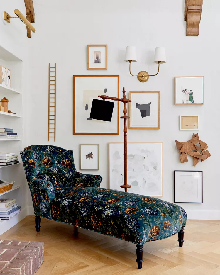 Eclectic home library with floral chaise lounge and gallery wall art display
