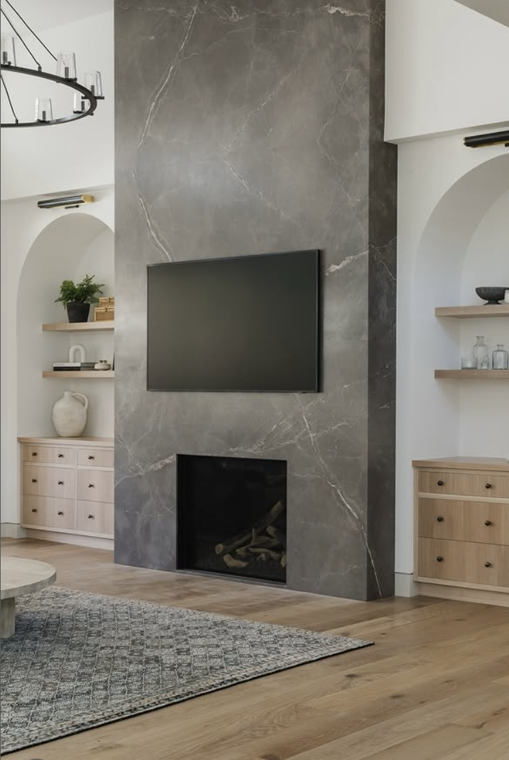 Modern living room with floor-to-ceiling gray slab fireplace and wall-mounted TV above