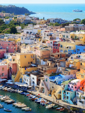 Naples: The Birthplace of Pizza - Panoramic view of the old village of fishermen's houses and the marina of Corricella, a classic panoramic view of the island of Procida, Italy.