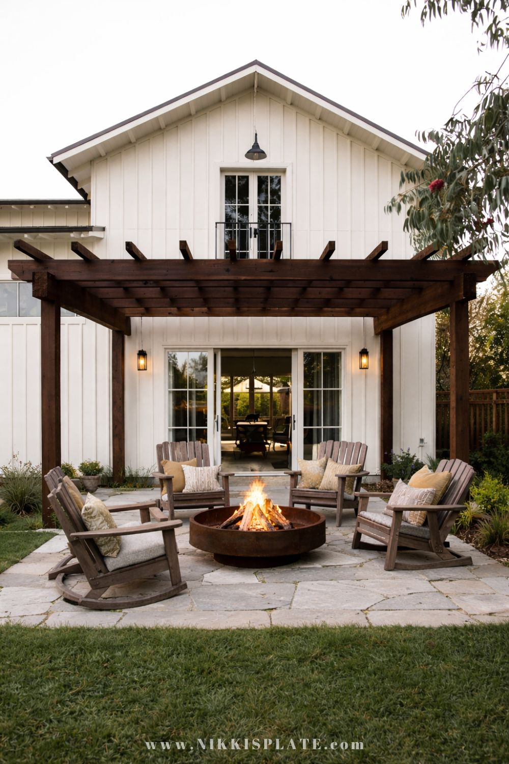 Farmhouse style rustic fire pit with wooden pergola seating area and Adirondack chairs
