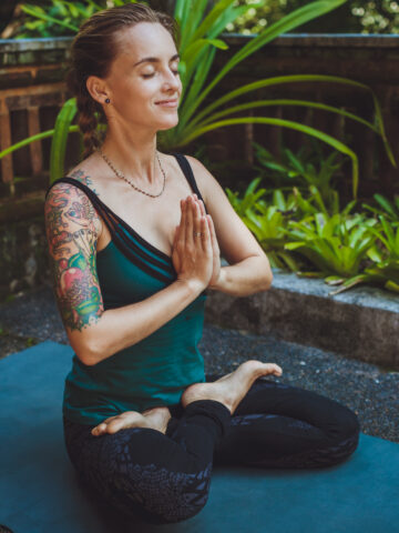 A Young woman doing meditation outdoors in tranquil environment