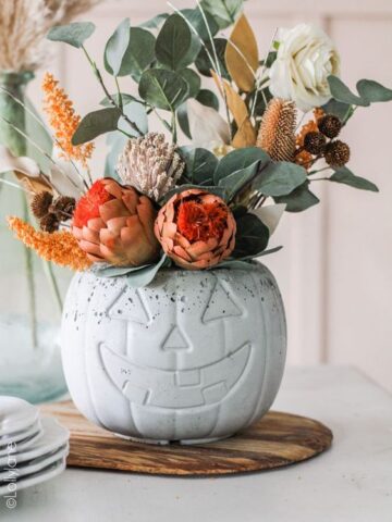 Halloween Pumpkin Decor Ideas: Turn your pumpkins into planters by hollowing them out and filling them with your favorite fall flowers or plants. This is a great way to bring some life to your Halloween decor. Opt for brightly colored flowers, such as orange marigolds or purple pansies, to complement the pumpkin's natural hue.