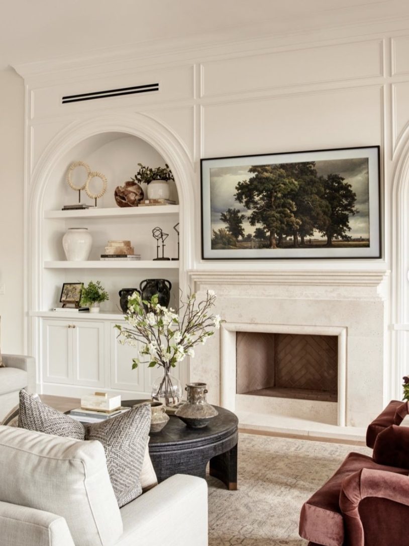 Living room with built-in shelving and custom millwork surrounding a fireplace, featuring warm neutrals and styled decor, showcasing living room trends for 2026.