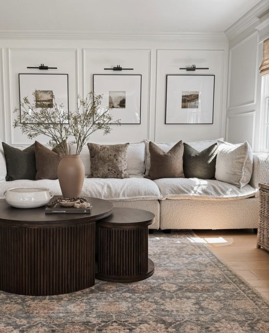 Cozy minimalist living room with warm neutral seating, layered textures, simple wall art, and soft natural light, reflecting cozy living room trends for 2026.