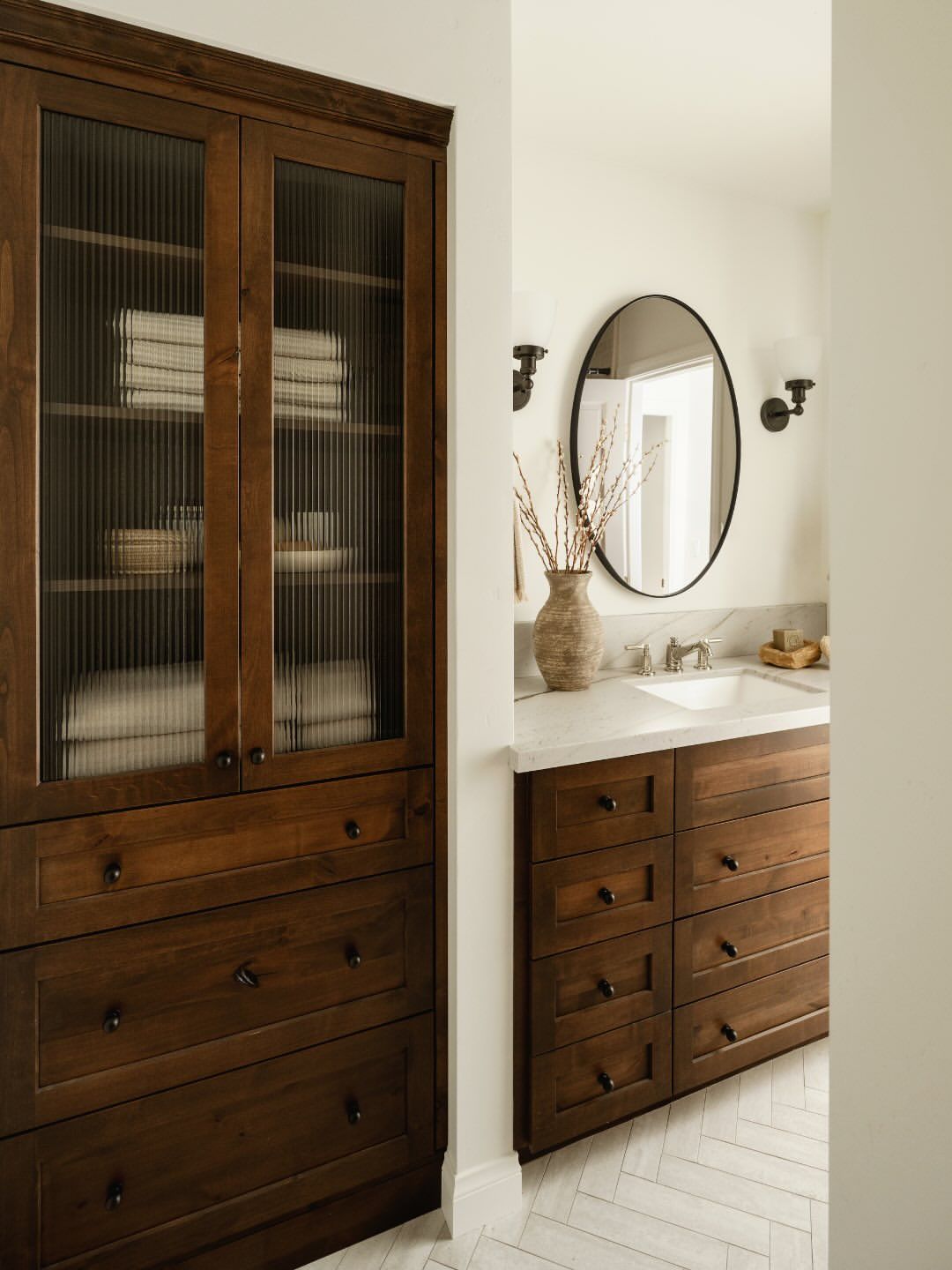 Natural wood bathroom cabinets with textured glass doors and warm finishes showcasing bathroom trends for 2026 with organic materials and layered texture