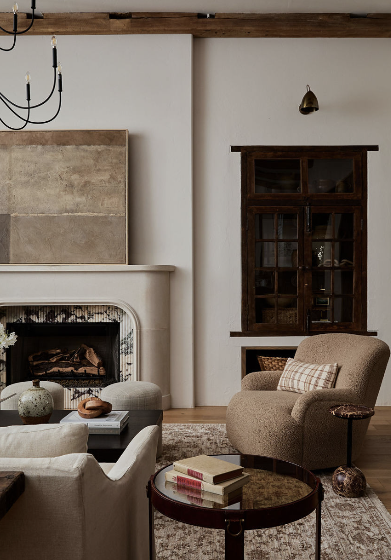 Living room featuring statement art and maximalist wall decor with warm neutral furniture, layered textures, and vintage-inspired accents, showcasing living room trends for 2026.
