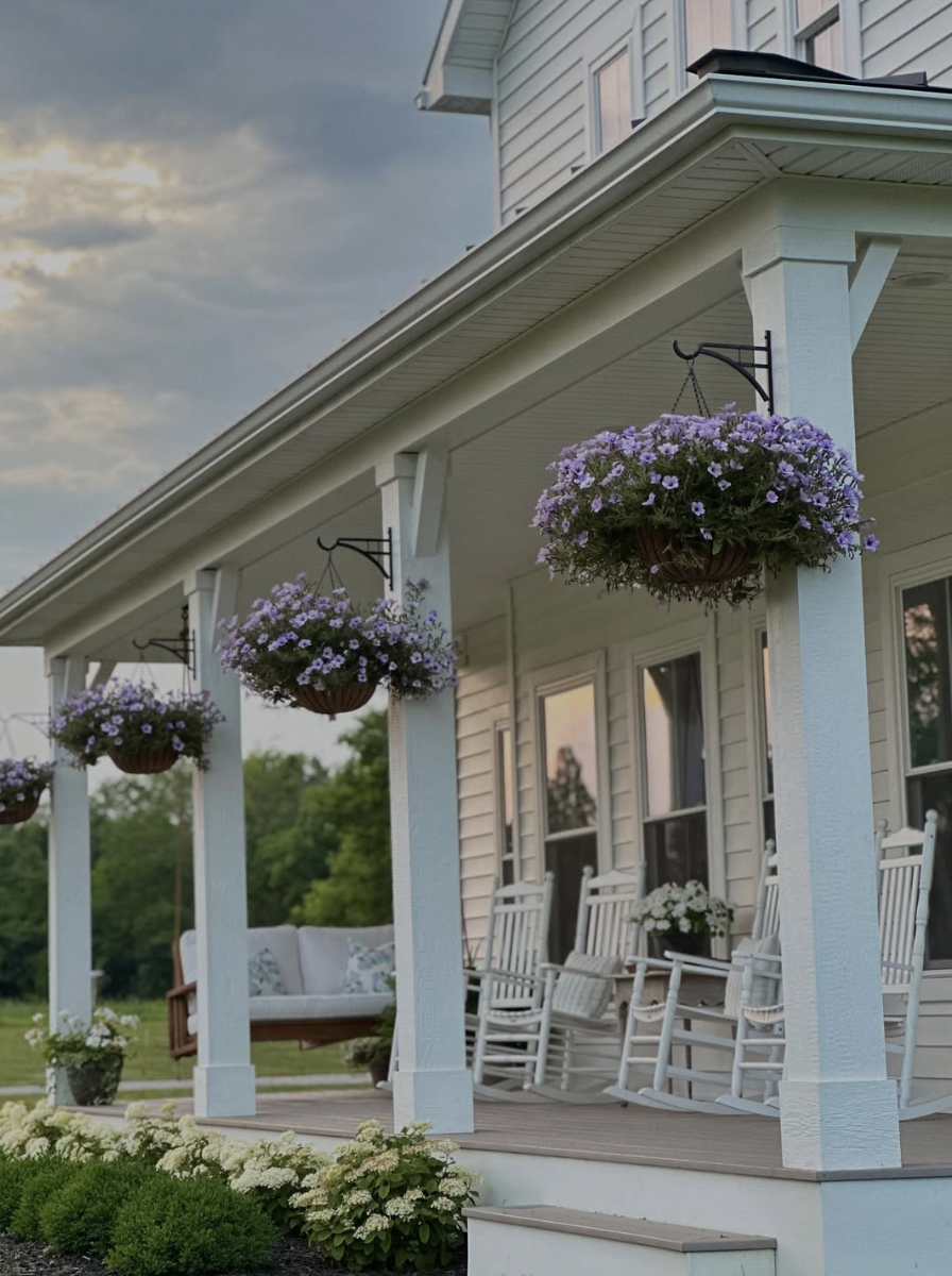 farmhouse back porch with hanging flower baskets and rocking chairs