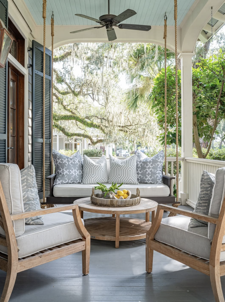 small back porch seating area with swing and cozy cushions