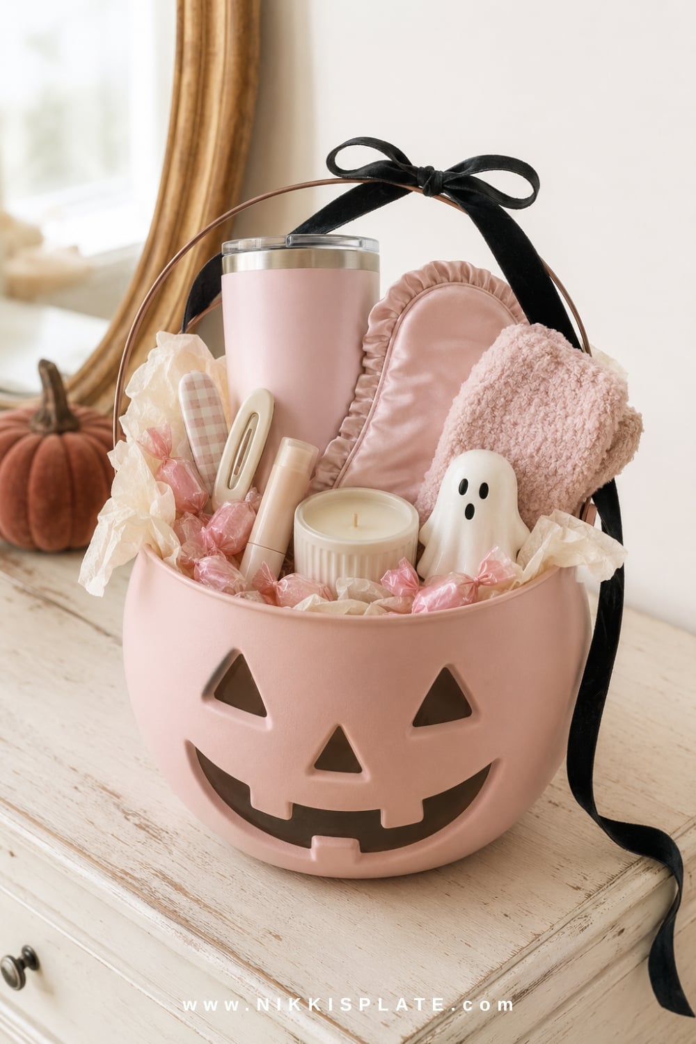 Pink and black boo basket with a blush pumpkin pail, tumbler, fuzzy socks, lip balm, candy and ghost accents.