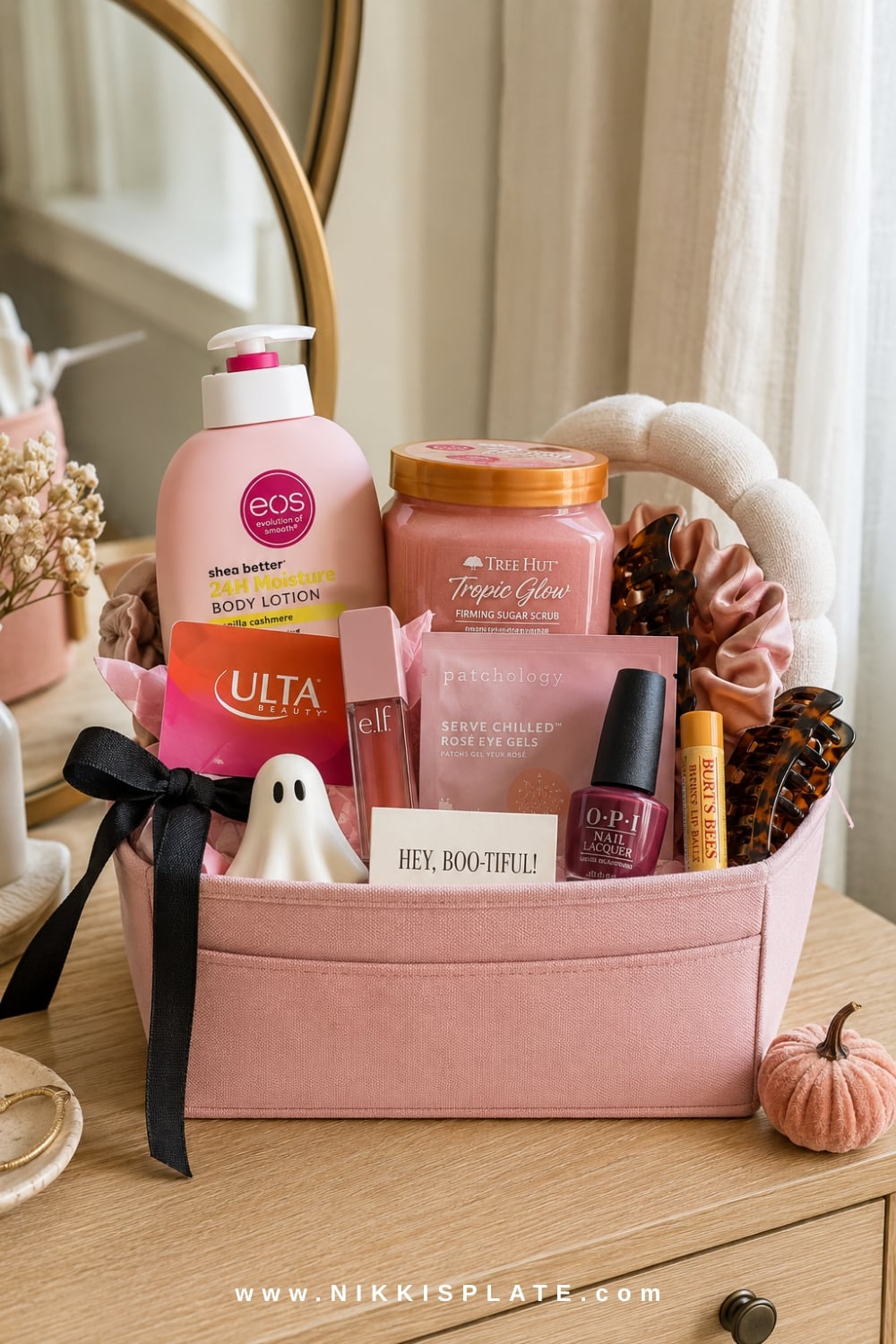 Pink beauty boo basket with an Ulta gift card, e.l.f. lip oil, Tree Hut scrub, eos lotion and Halloween accents.