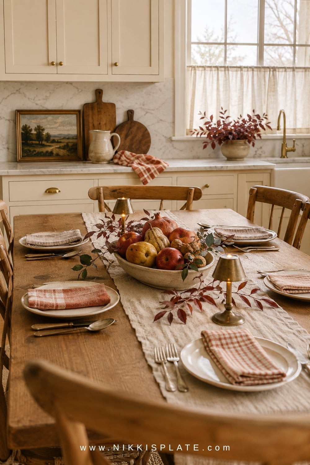 Fall dining table with striped linen, brass candlesticks, pears, pomegranates, and warm wood