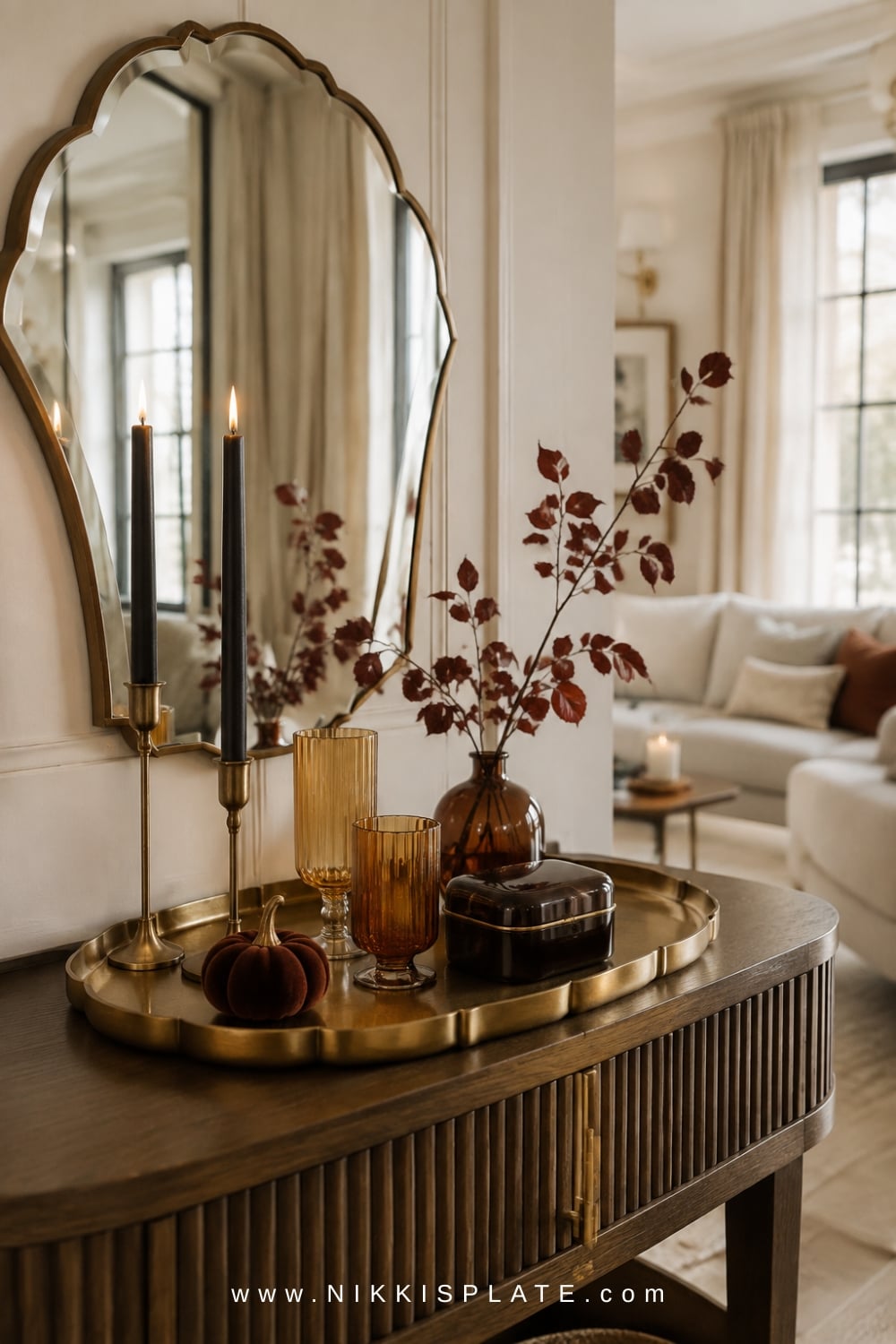 Neo Deco fall vignette with a scalloped brass tray, amber glassware, and black taper candles