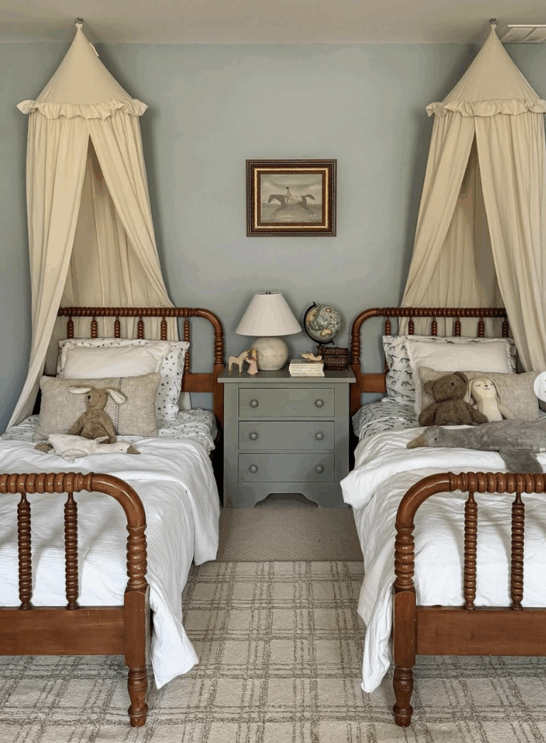 These rich wood spindle antique twin beds feature classic turned spindle posts, adding warmth and texture to this whimsical children’s bedroom. Draped canopy accents, a vintage-style globe, and soft neutral textiles create a timeless, storybook feel. Perfect for a traditional or English cottage–inspired space, these beds prove that antique twin frames can be both practical and magical.