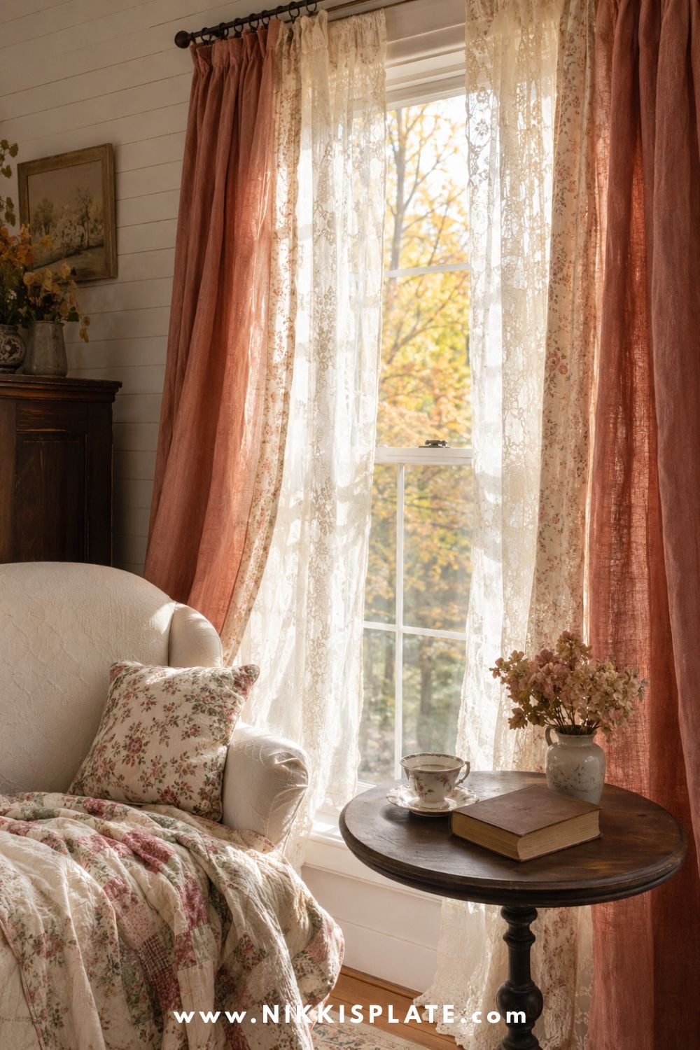 Ivory lace curtains layered with muted autumn drapes beside a quilted chair in a softly lit grandmacore reading corner.