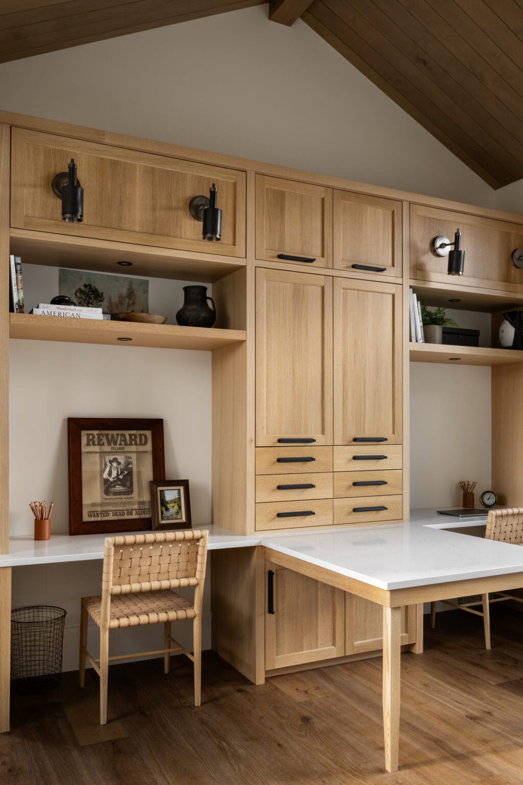 Studio McGee office featuring light oak built-in cabinetry, black hardware, and white quartz countertops with a double desk setup.