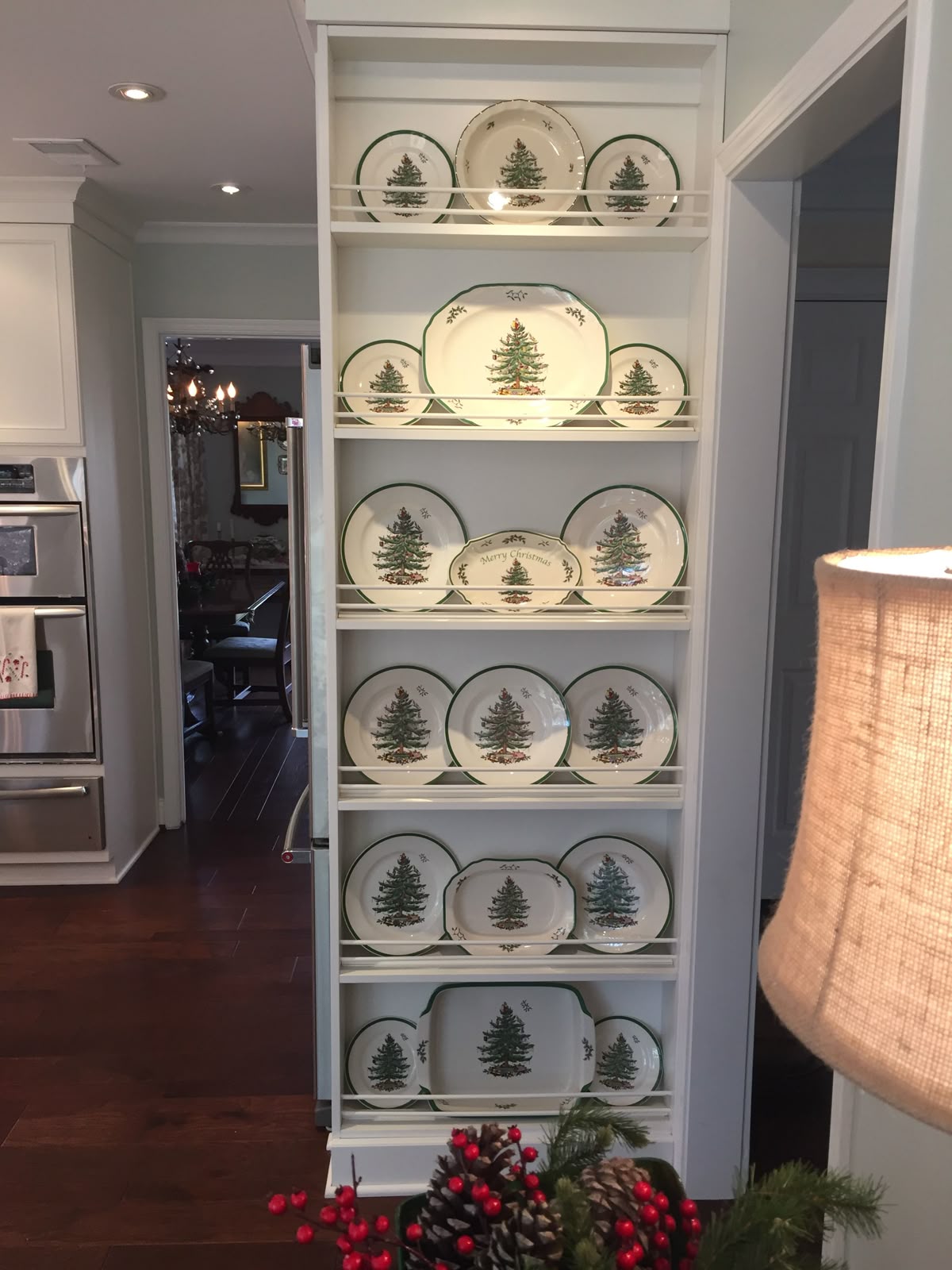 Built-in kitchen shelving with Spode Christmas Tree plates arranged for a festive holiday plate wall display.