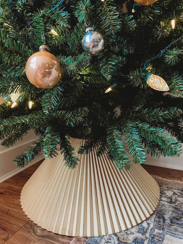 DIY pleated paper Christmas tree collar used to hide the tree stand and create a stylish modern holiday decor look.