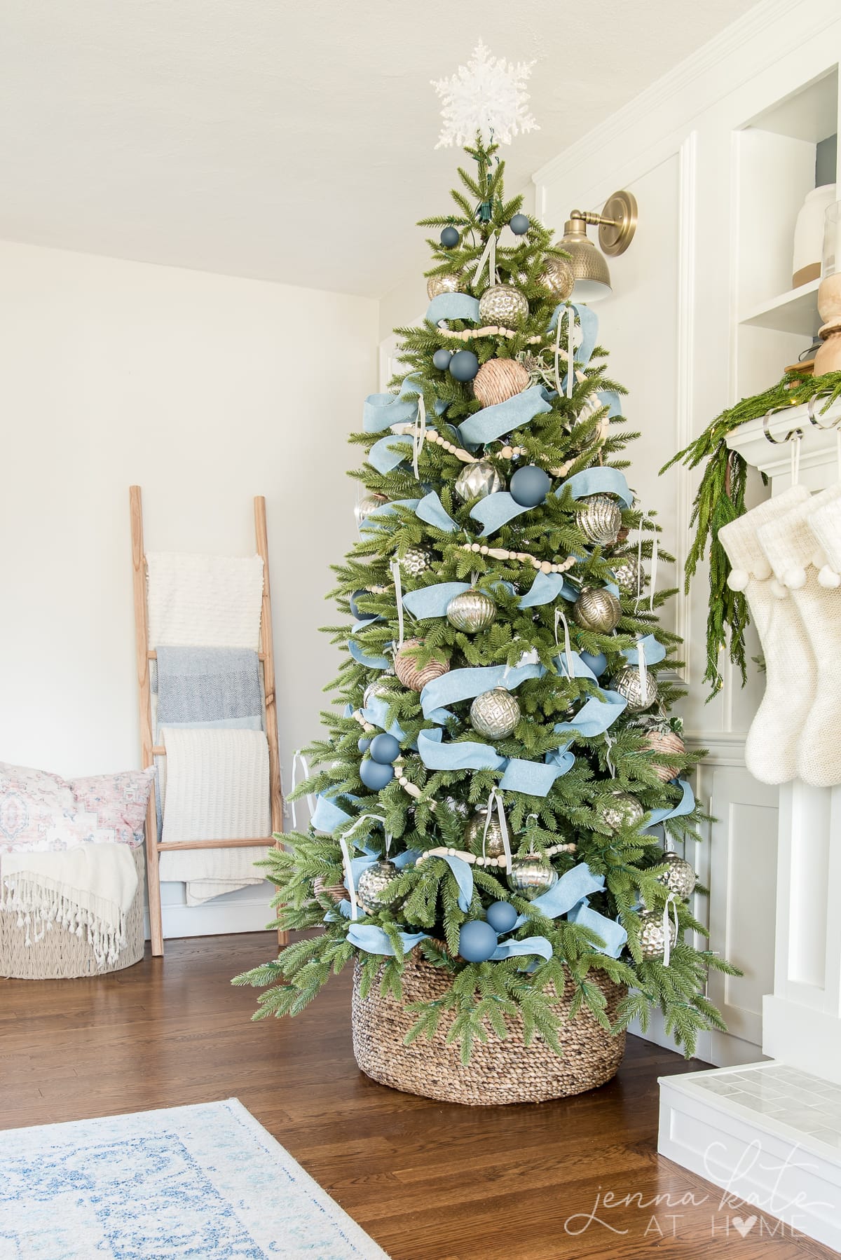 Christmas tree with a woven basket tree collar and blue ribbon decorations for a cozy farmhouse holiday style.