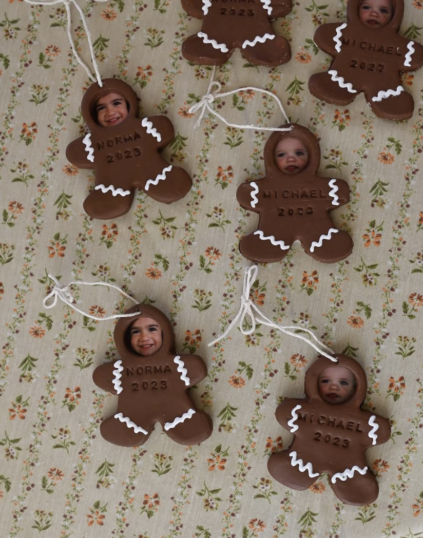 DIY clay gingerbread photo ornaments shaped like cookies with children's faces, white icing details, and names stamped with the year