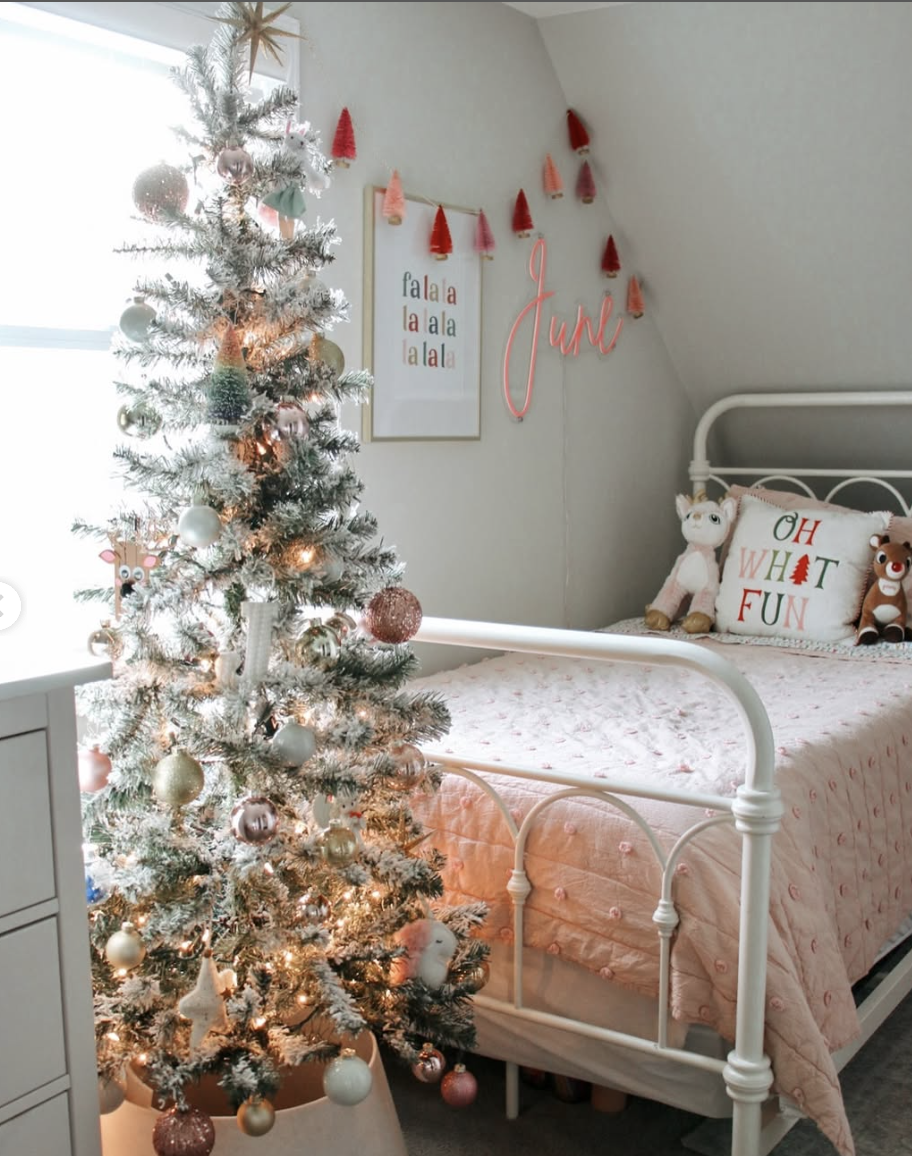 cozy farmhouse kids christmas bedroom with pink bedding, frosted christmas tree, and festive holiday accents