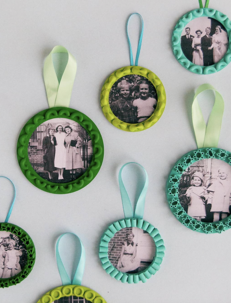 DIY pasta frame photo ornaments made with painted noodles in shades of green, yellow, and teal framing vintage black and white family photos with ribbon hangers