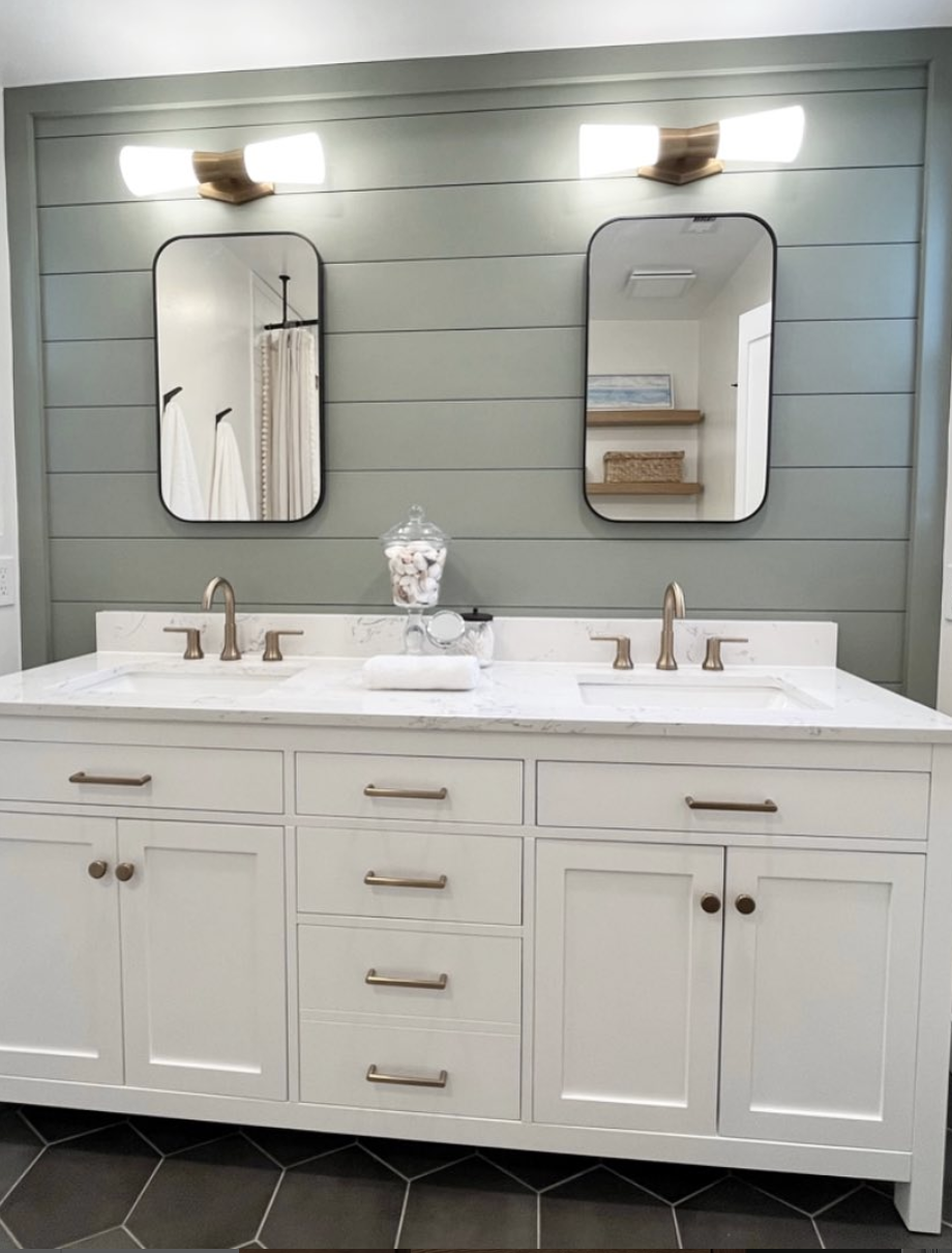 Bathroom with Sherwin-Williams Evergreen Fog shiplap feature wall, double vanity, brass fixtures, and modern black-framed mirrors.