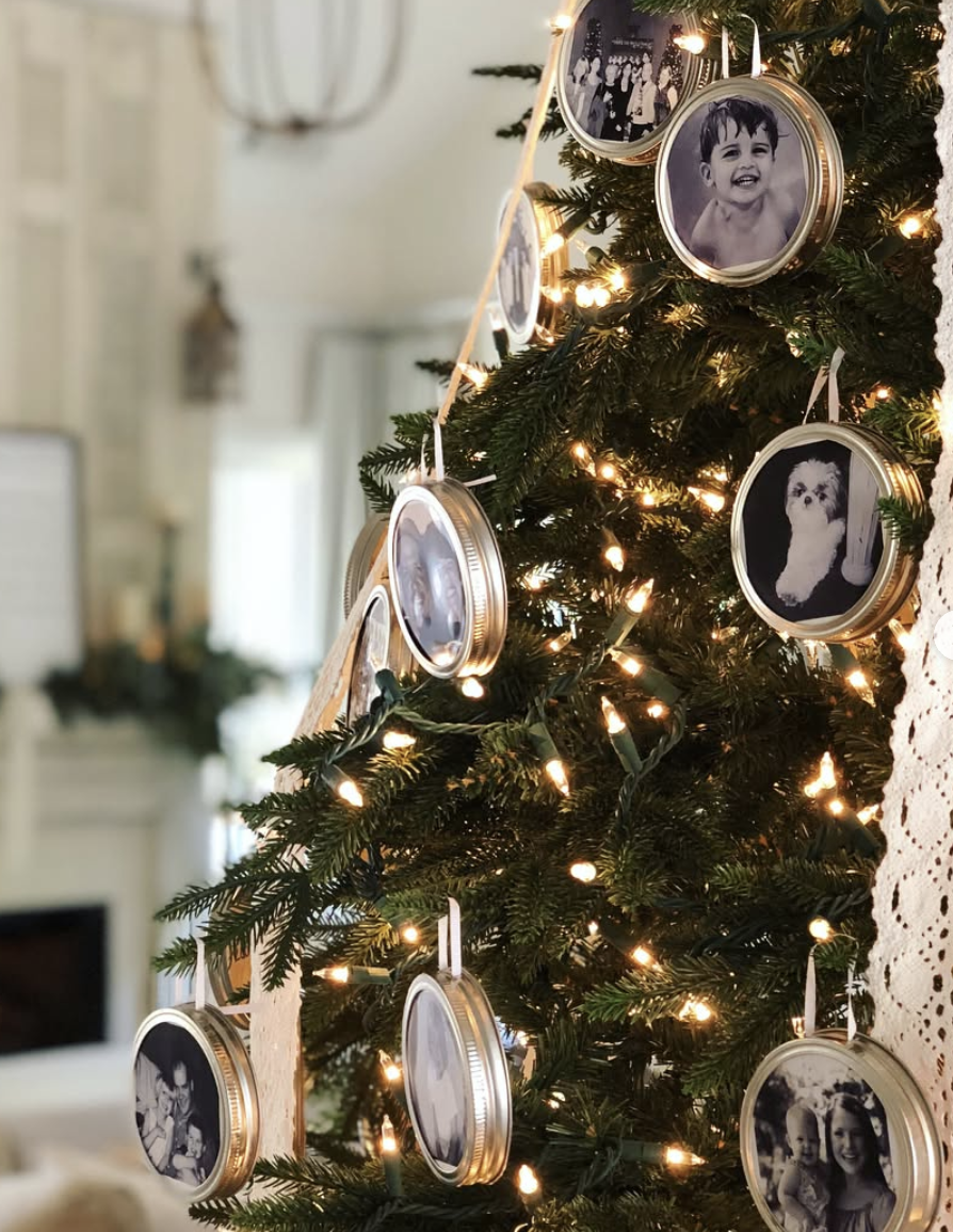 DIY mason jar lid photo ornaments with black and white family photos hanging on a Christmas tree with warm white lights and neutral farmhouse decor