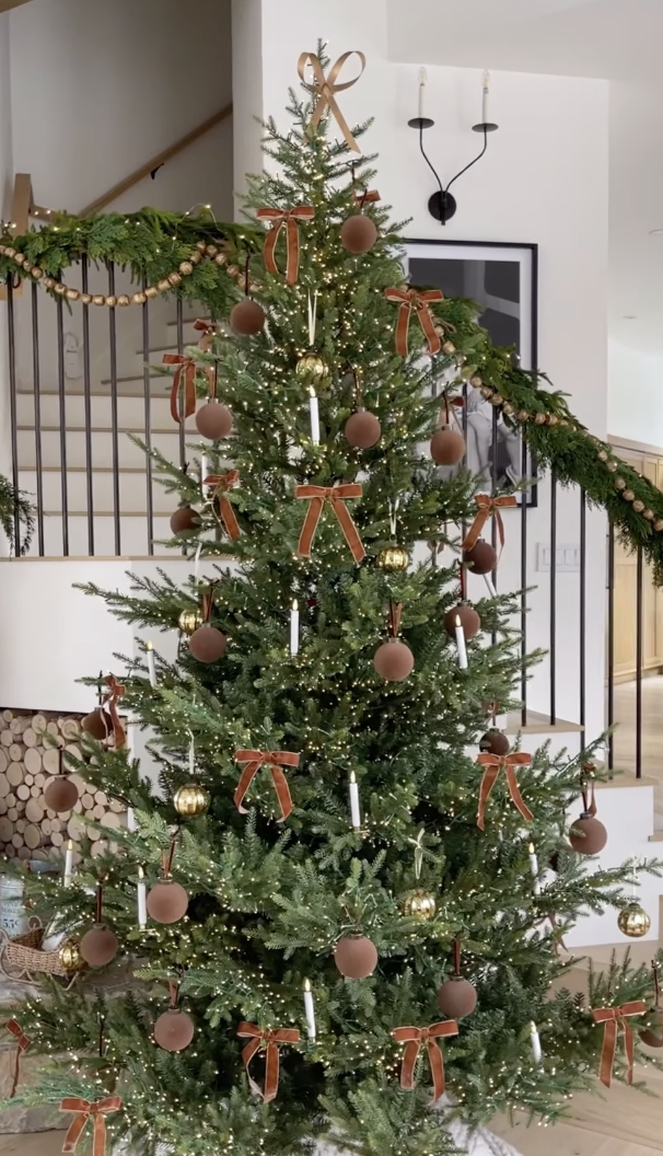 modern farmhouse Christmas tree with brown velvet bows, matte ornaments, and glowing candles in cozy neutral holiday living room