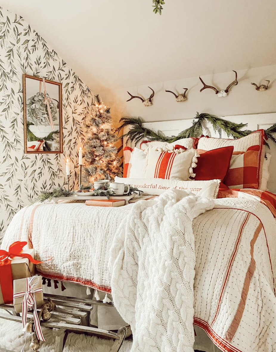 red and white farmhouse christmas bedroom with patterned wallpaper, red striped bedding, and small christmas tree