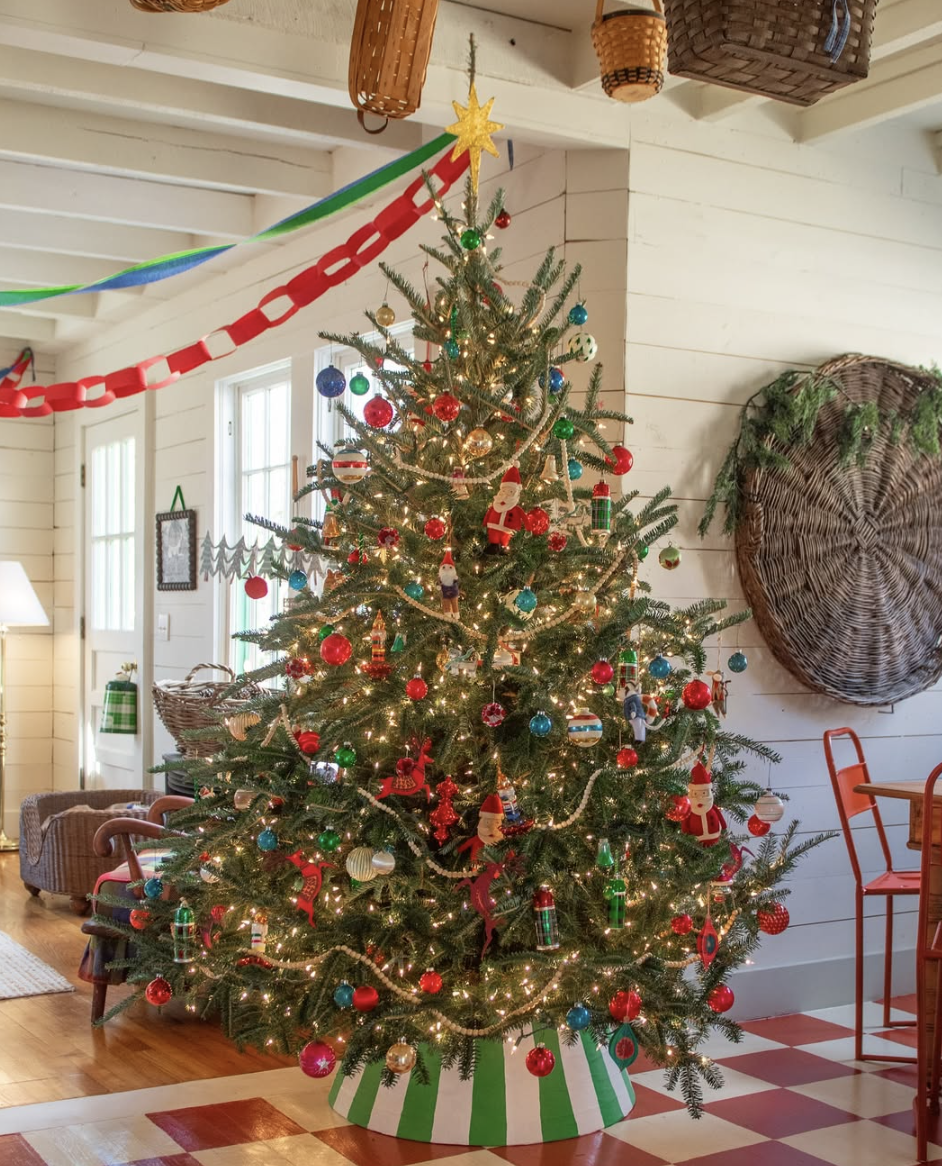 rustic farmhouse Christmas tree with colorful ornaments, Santa figurines, and paper garlands in cozy country cottage living room