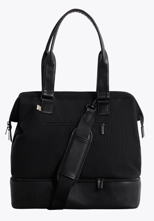 Woman carrying the black BÉIS Mini Weekender bag with structured bottom compartment.