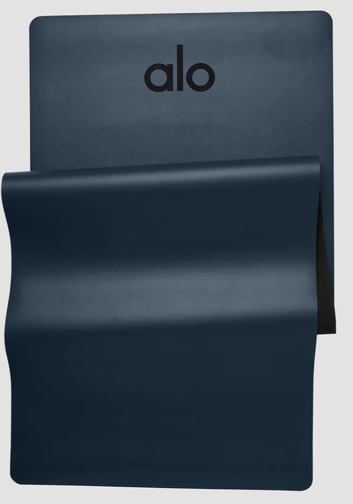 Navy Alo Yoga Warrior Mat unrolled to show thick cushioned surface with Alo logo.