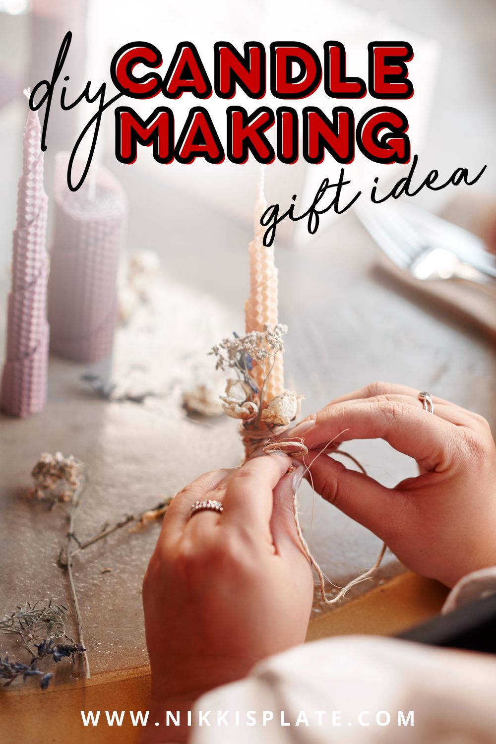 Hands crafting homemade beeswax candles decorated with dried flowers - a cozy and natural homemade homemaker gift idea for Christmas.