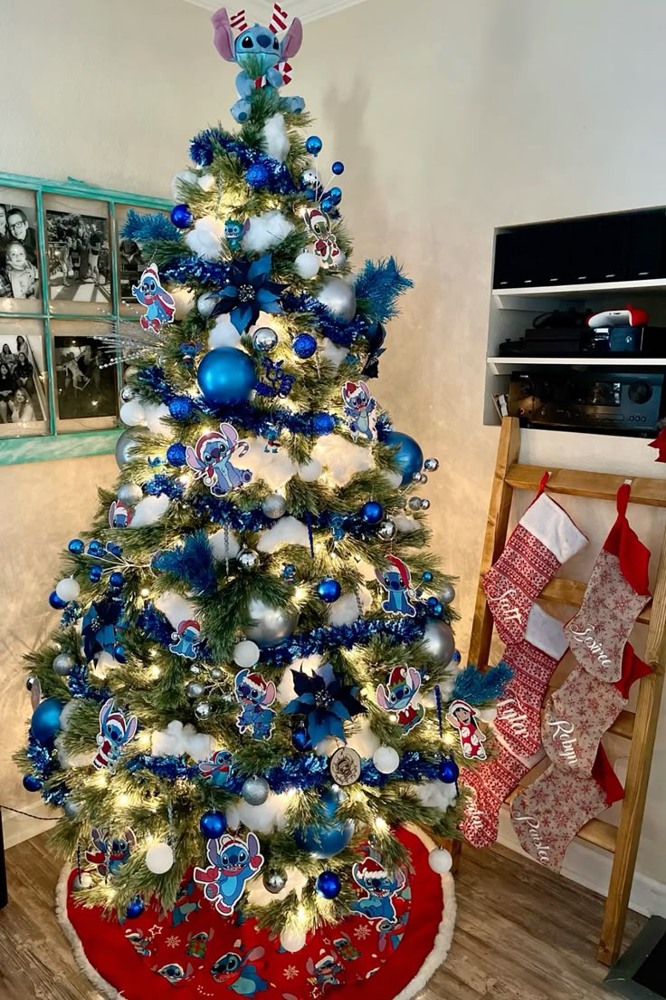 Christmas tree decorated with blue and silver ornaments, DIY Stitch cutout ornaments, blue garland, and a Stitch tree topper for a fun Lilo & Stitch holiday theme.