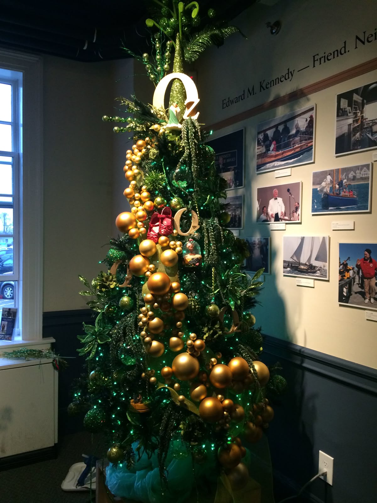 Emerald City inspired Wicked Christmas tree decorated with gold ornaments, green lights, and the letter 