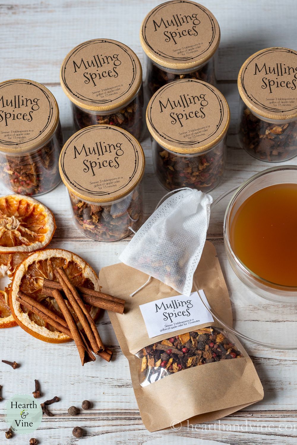 Jars and sachets of homemade mulling spice and herbal tea blend - a cozy and thoughtful homemade homemaker gift idea for Christmas.